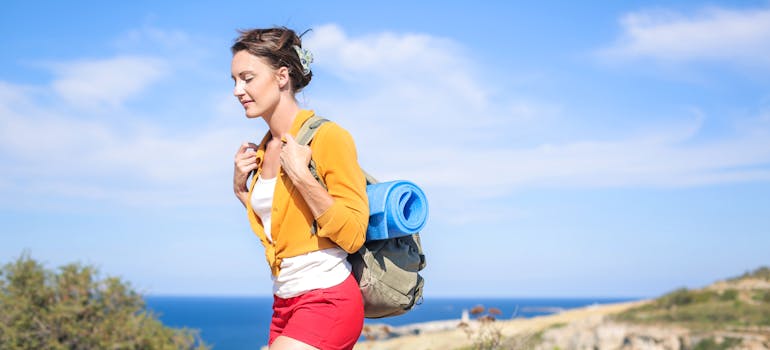 A woman carrying a yoga mat