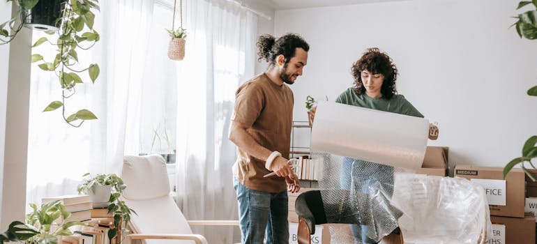 A couple packing for a move and talking about the cost of moving across Canada