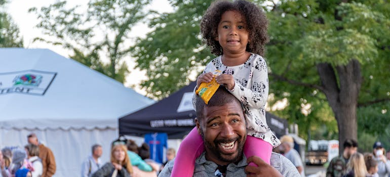 a child and her dad having fun on the festival, small towns in Ontario for a peaceful move