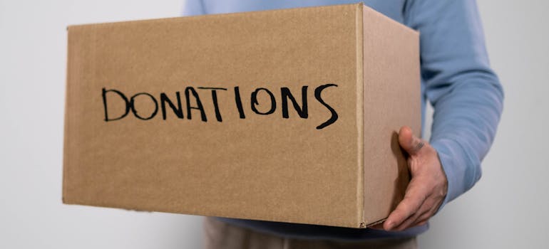 A person holding a box with donations