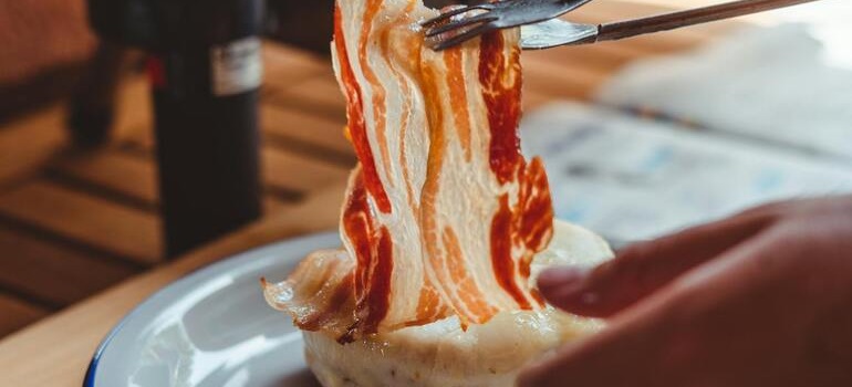 a person preparing peameal bacon sandwich in Toronto