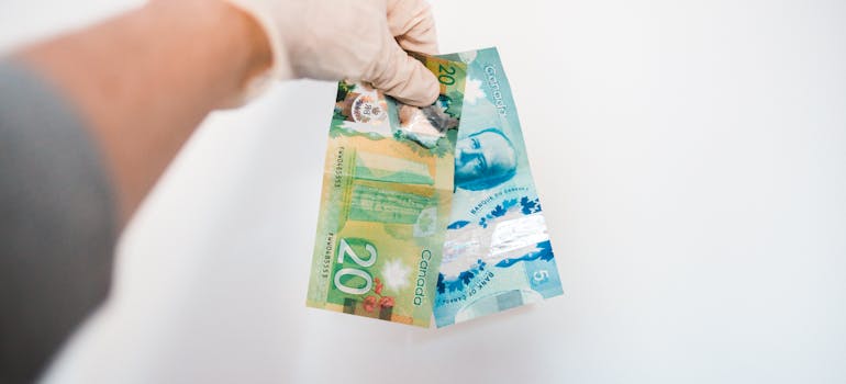 A person holding Canadian dollar bills