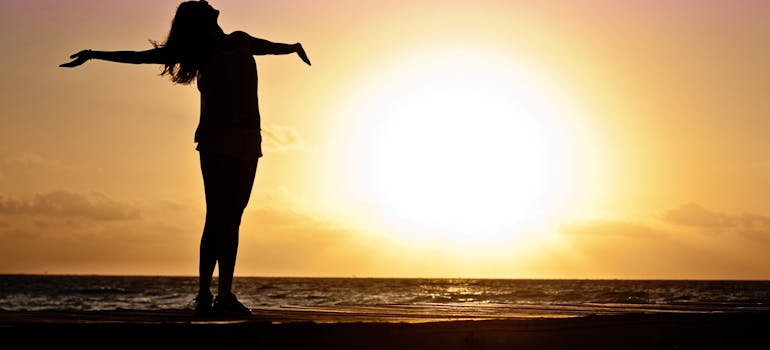 A woman on the beach enjoying the sunset