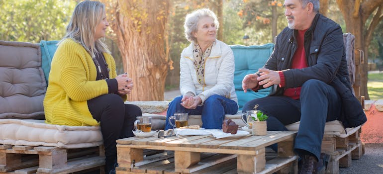 Three people in the park having tea