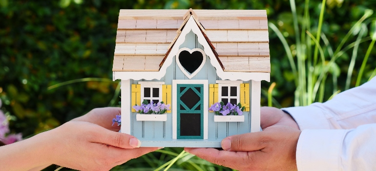 a couple holding a small house adapting to Canada's soaring rental market