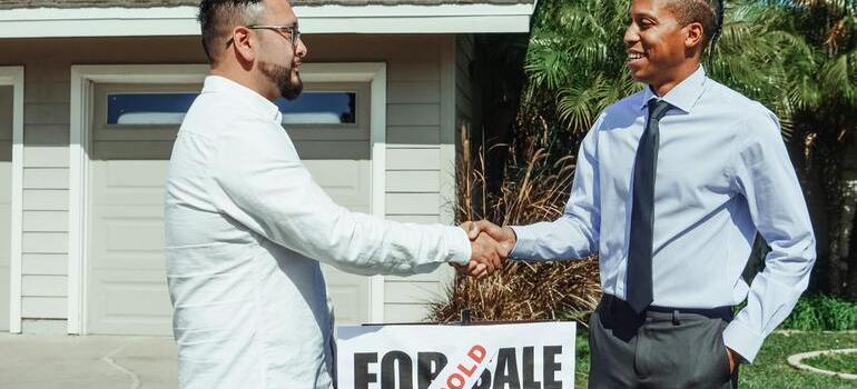 a man who has found affordable housing in Toronto in 2025 shaking hands with a realtor who helped him