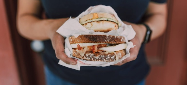a person holding a sandwich