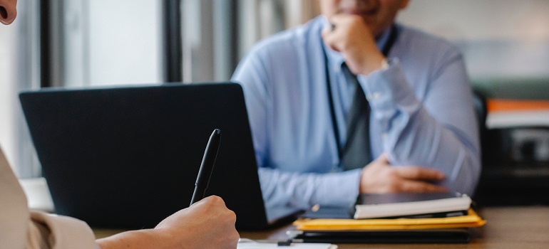 a man at a job interview taking notes