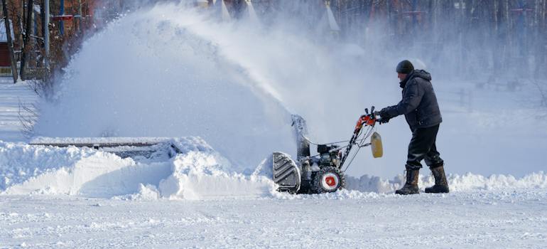 A man clearing snow and preparing for moving during winter in Canada